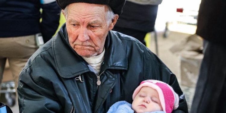 Дідусь, який колише свою онучку, тікаючи з-під обстрілів (відео)